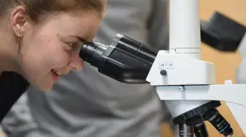 Student looking through microscope 