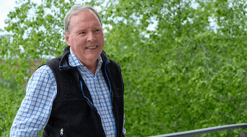 Man in black fleece vest leaning against railing
