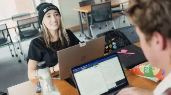 Student smiling over laptop