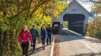 people walking near a covered bridge