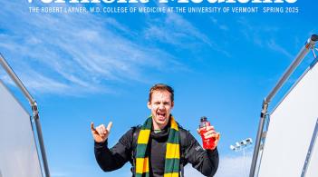 Man in a green and yellow striped scarf making a hang loose sign as he tops out the stairway at airport