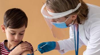 nurse giving vaccine to a boy