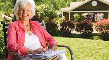 a woman sits in a chair on a lawn