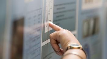person pointing to data on a research poster