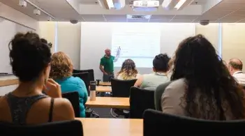 group of learners sit in front of a person giving a lecture