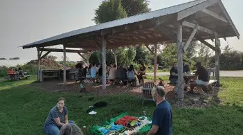 Group having picnic under wooden structure