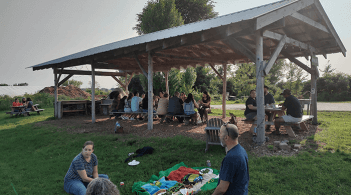 Group having picnic under wooden structure