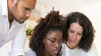 three people looking at a computer