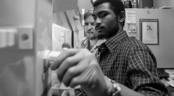 two people turning a dial conducting research