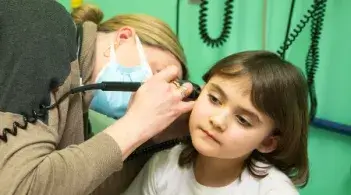doctor looking into the ear of a young patient