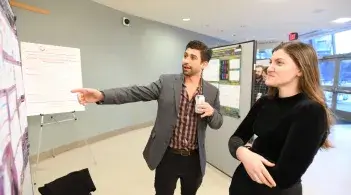 two researchers in front of poster