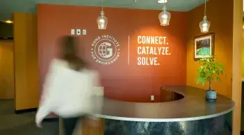 A blurry person walking by a desk
