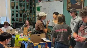 Students gathered in a classroom filled with debate plaques and posters.