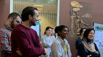 Group of graduate students attending an event and listening to a presentation