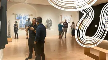 People discussing the artwork in the Kimono exhibition. 