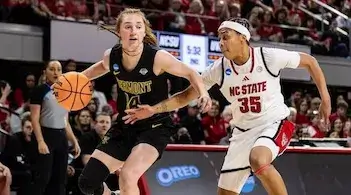 two women playing college basketball, one driving downcourt