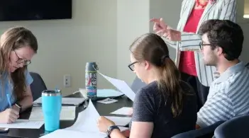 three students study at a table