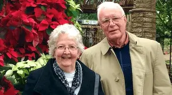 a woman and a man standing in front of a floral display