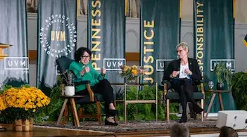 two women sitting on a stage talking