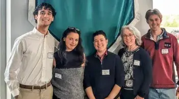 Interim UWC Director Holly Painter and UWC Director Sheila Boland Chira stand smiling in the middle of a group of three Spring 2025 English 2795 students in front of a green Suny Adirondack banner.