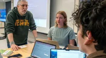 Students discuss an assignment with their computer science professor