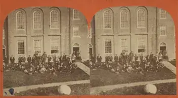 Historic stereograph of Old Mill and a group gathered on the west lawn of the University of Vermont campus.