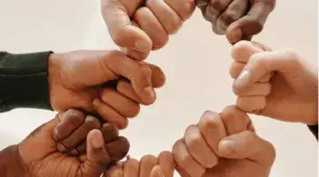 fists in a circle, photographed from below, a collective fist bump