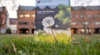 Grossman School's Year in Review booklet posed in front of Kalkin Hall