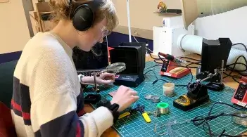 Student soldering electrical components