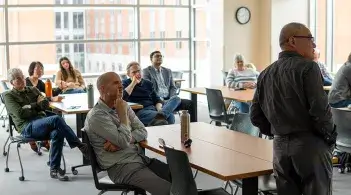 A group of faculty and students sit in a classroom and listen to a lecture as part of the Research Seminar Series