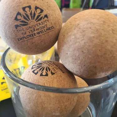 Three cork balls with the UVM Employee Wellness logo on them