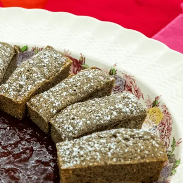 Financiers on a white plate arranged around strawberry compote