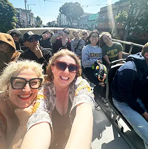 group of smiling students on an open bus in San Francisco