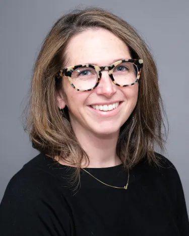 A person wearing a black shirt and glasses