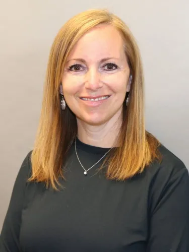 A person wearing a necklace and a dark shirt