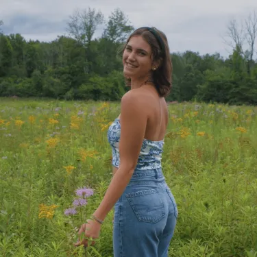 Headshot of Bianca standing in field of flowers