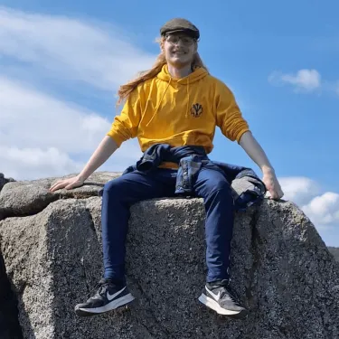 Headshot of Parley (blue sky behind student sitting on a rock)