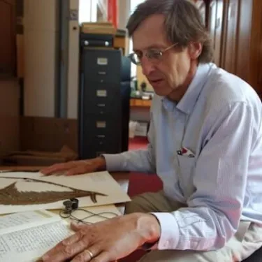 Barrington surveys plant specimens at his desk