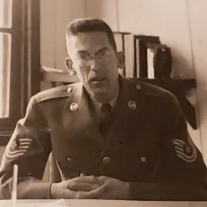 Charette in uniform sitting at a desk