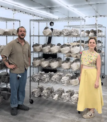Two people standing in front of a lion's mane growing rack