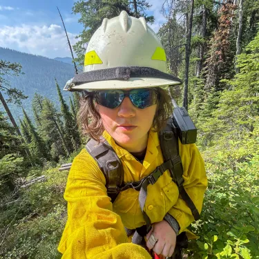 Alannah in the woods in a helmet.