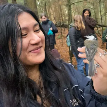 Nina holding a bird in her hand.