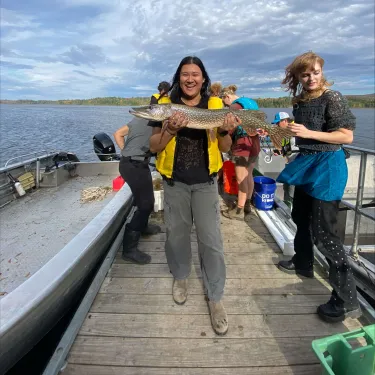 Nina holding a large fish on a dock.
