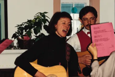 Katie Shepherd playing guitar at a party