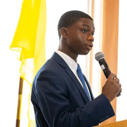 Danny Philip holds a microphone while giving a presentation