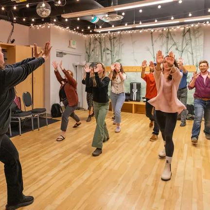 A group of students practicing palm heal strikes in the air
