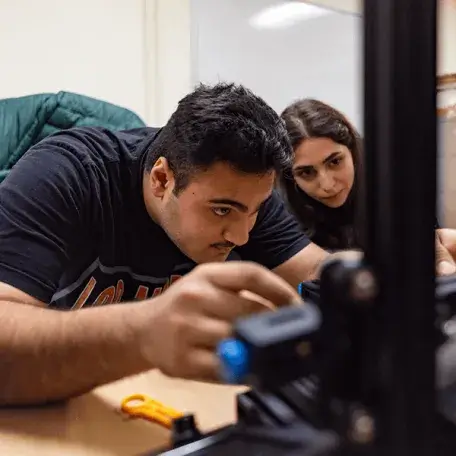  Two students work on building a drone