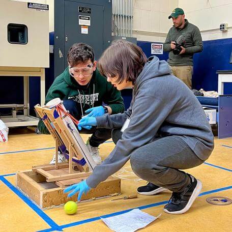 two students working on a tennis ball cannon