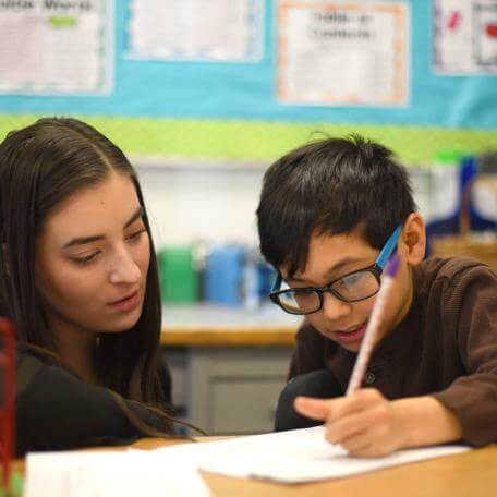 Student teacher with child in school field placement