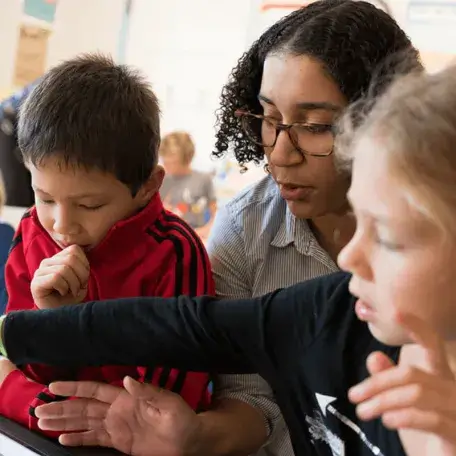 A student works with kindergarteners